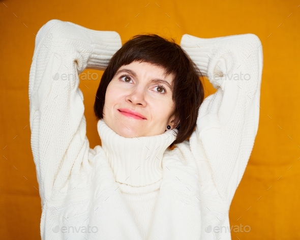 Portrait of mature woman pleased satisfied with herself, smiling and dreaming with self-reflection