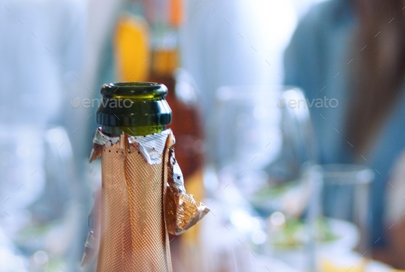 an open champagne bottle with the foil removed from the neck from the glass neck