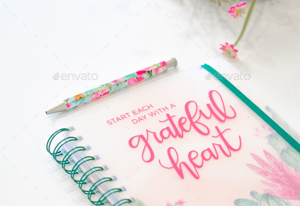 Grateful heart journal and floral pen on a white background