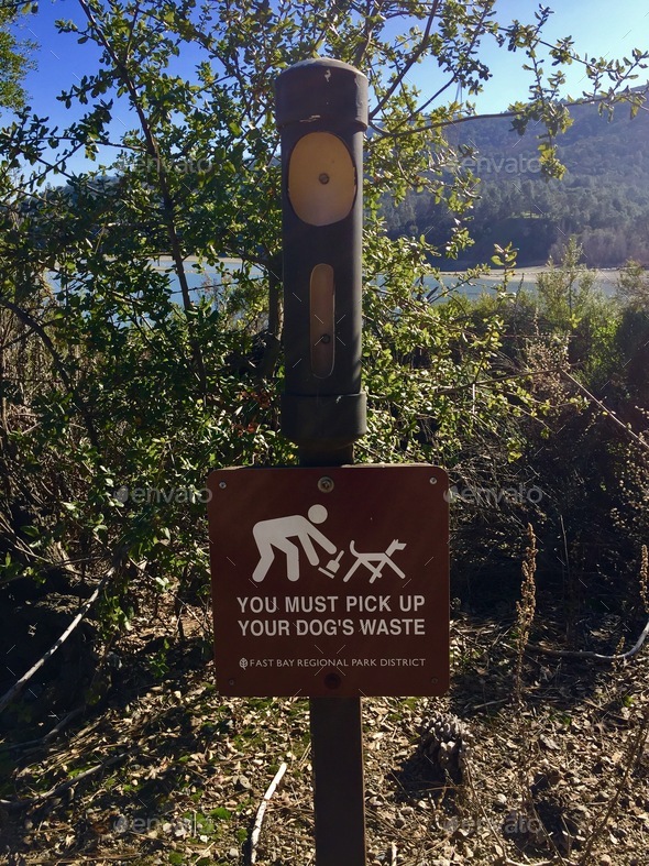 Sign in recreational area instructing people to pick up dog waste