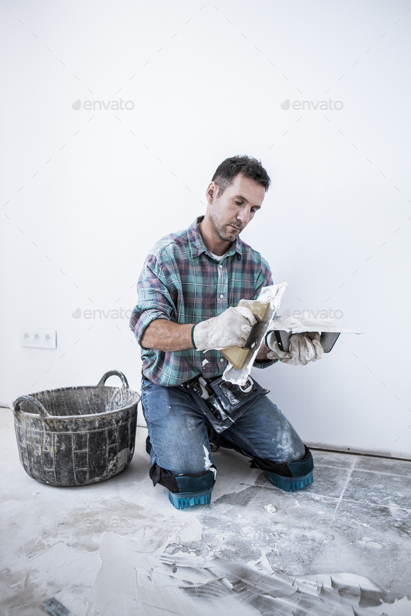 A mason prepares the putty using a tile grout to cover the tile joints.