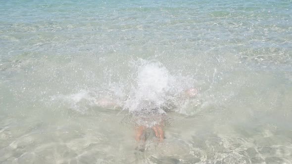 Happy Child Plays in the Azure Sea a Boy Falls Into the Sea Enjoying the Sea Water on a Sunny Hot