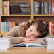 Tired student got asleep on the desk while studying among books - PhotoDune Item for Sale