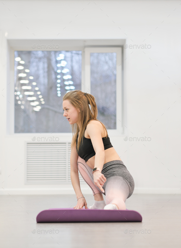 woman fitness trainer showing how to stretch legs on a mat. fitness club intructor. - Stock Photo - Images