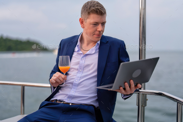 business man traveling holiday in the yacht use laptop checking work happy congrats get good news