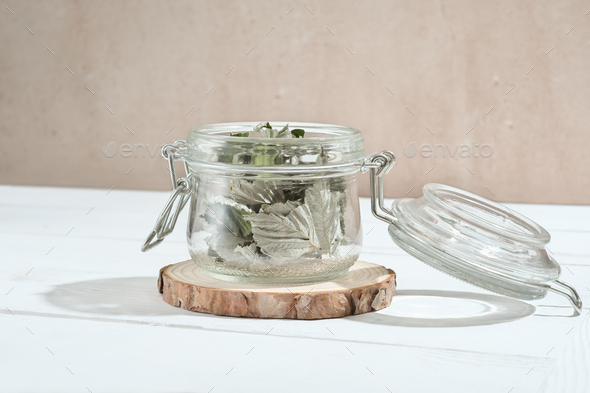 transparent glass jar with dry raspberry leaves for herbal tea. herbs for calming tea.  - Stock Photo - Images