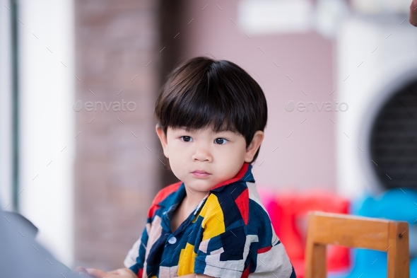 A 2-3 year old Asian boy shows a face that he is wondering about something.