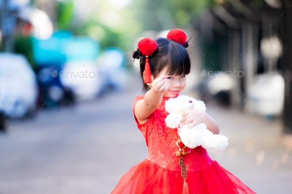 Selective Focus at child hand show mini heart. Adorable child girl holding hug white teddy bear.