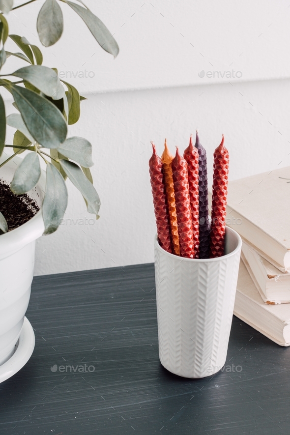 Wax candles in the interior of the house surrounded by household items