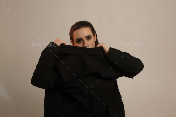portrait of a beautiful young girl in a black jacket worn backwards
