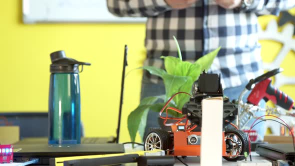 Crop Anonymous Man Controlling Robot in Class