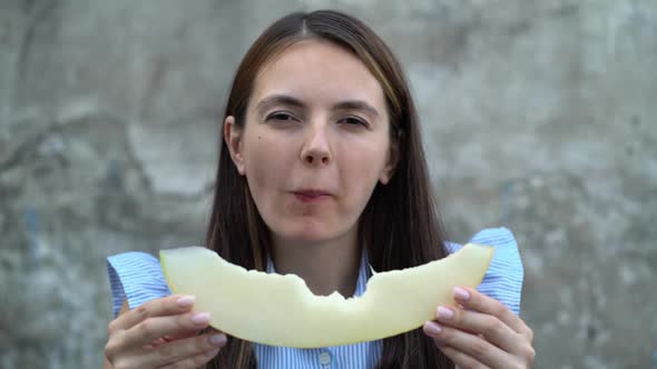 Portrait of a Beautiful Young Woman Eating Melon alt