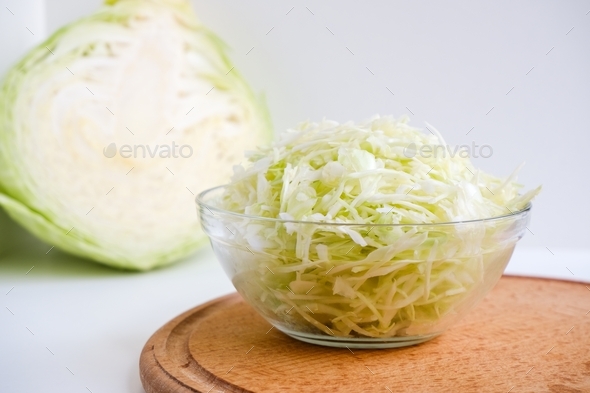 Shredded white cabbage on a wooden board. Fermentation of vegetables. Healthy food.
