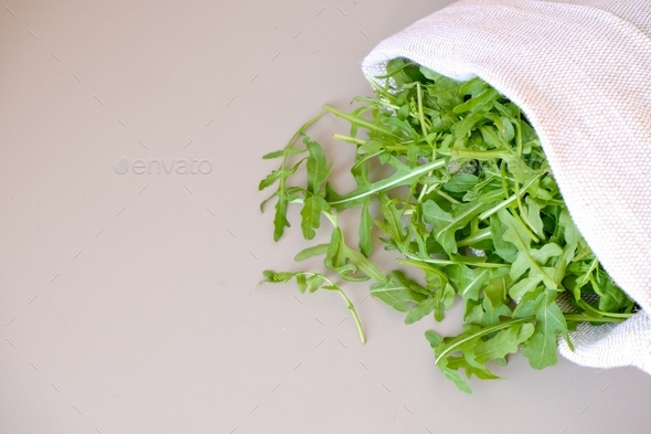 Fresh arugula in an organic textile bag on the table. Healthy food. Vitamins and minerals.