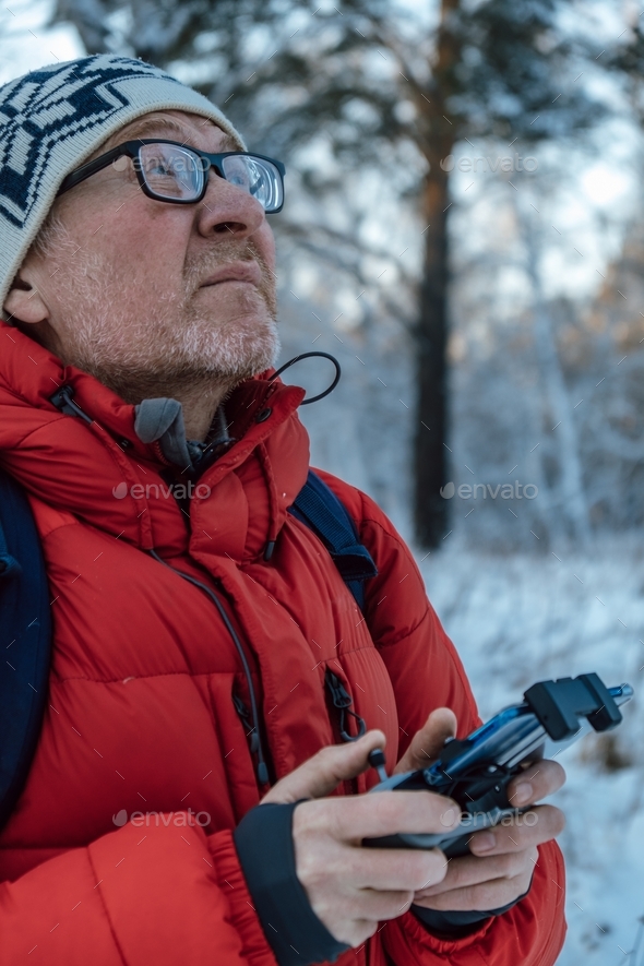 A man launches a drone from remote control. Shooting winter photos and video landscapes from drone.