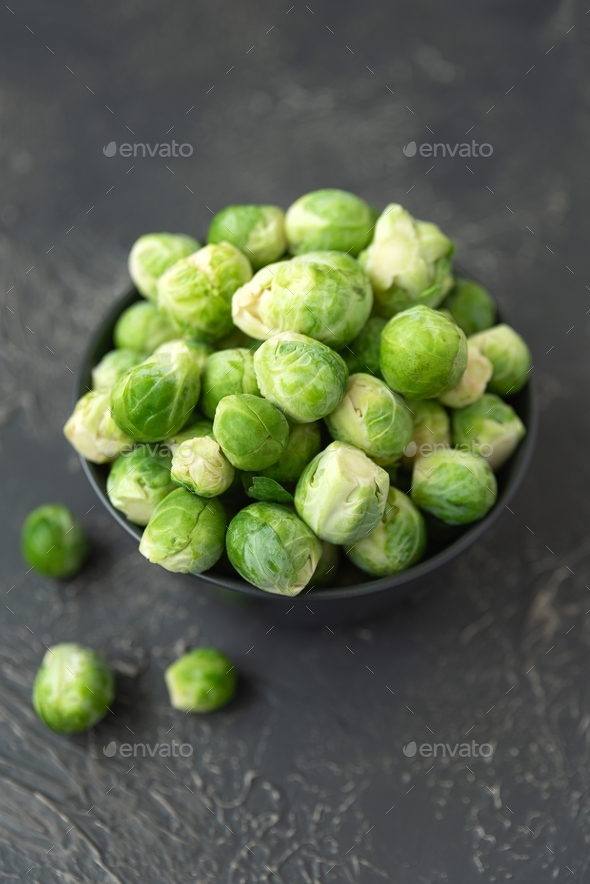 Close-up bowl with raw brussels sprouts on concrete background. Vegetarian food. Selective focus.