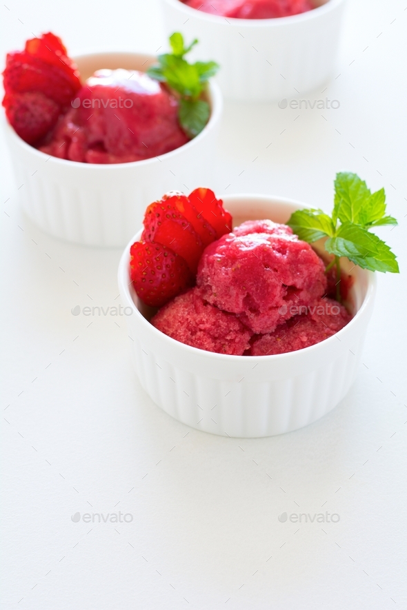 Fruit strawberry sorbet with mint in bowl on white wooden background. Frozen treats