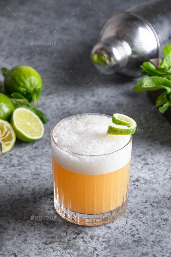 Alcoholic Pisco sour cocktail whiskey with lime, egg white, sugar syrup in glass. Stock Photo