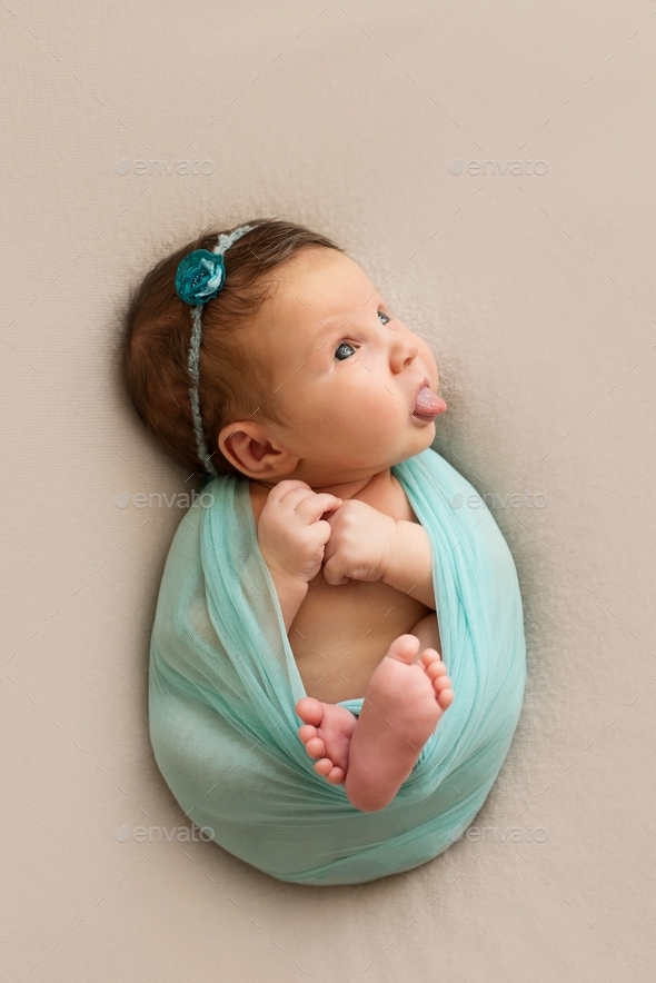Funny newborn baby girl with tongue out. Stock Photo by zharkovairina
