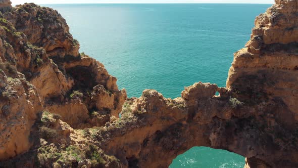 Fly-over 'Catedral' Stone Arch in Lagos, revealing Algarve Coastal sea, Portugal alt