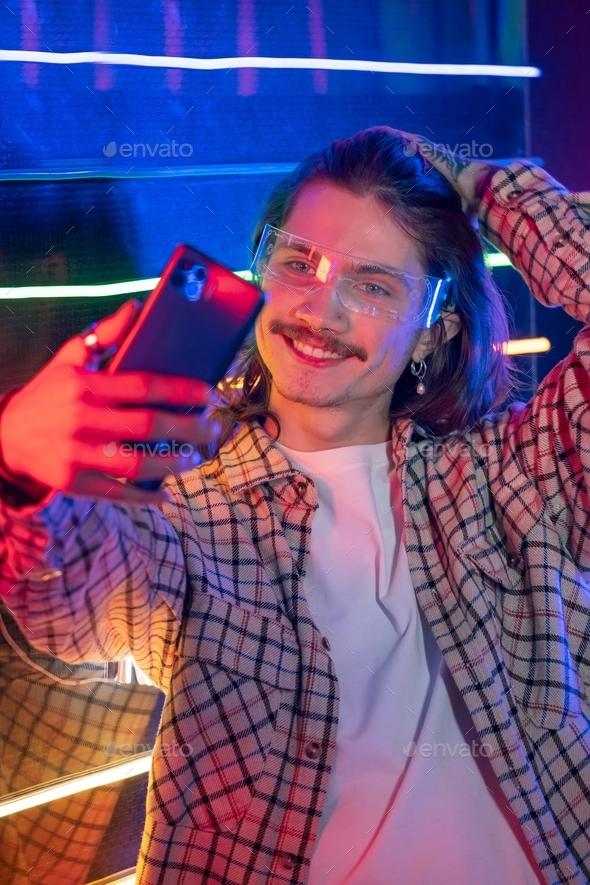 Man using smartphone and take selfie at night club with neon light Stock  Photo by gilitukha