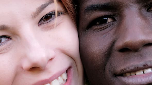 Interracial love concept. White woman and black man eyes looking at camera alt