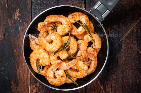 Fried with butter and garlic prawns shrimps in a skillet.