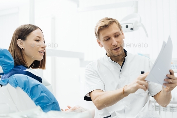 Doctor consulting his patient discussing tooth treatment plan. Health care