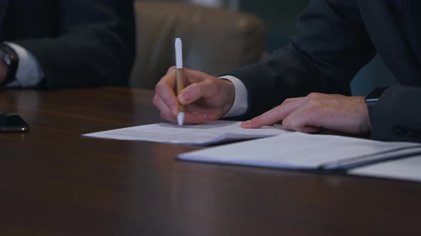 Businessman Puts Signature on Document Closeup
