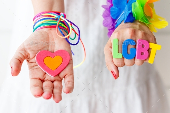 Woman with word lgbt on her hand, holding a colorful heart, rainbow, celebration, gender diversity