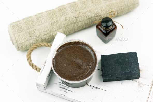 A chocolate scrub for body, a black hand made soap, a cooton towel, a natural oil for face