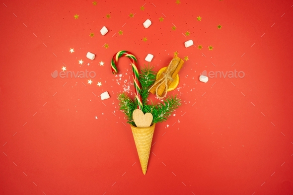 A waffle cone is full of confetti, colorful candy cane, dried orange, cinnamon