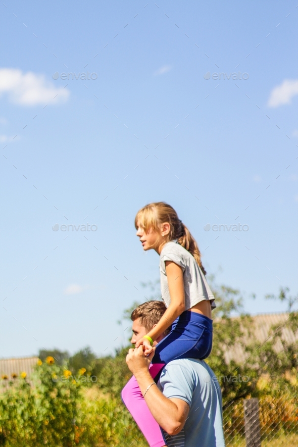 Family playing outside. Blue sky green tree background. Summer. Side view.