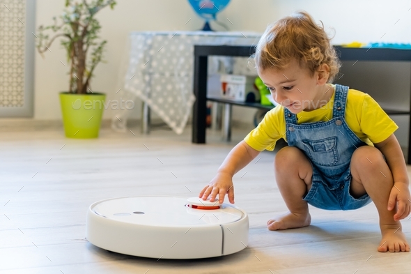 child starts a robot vacuum cleaner