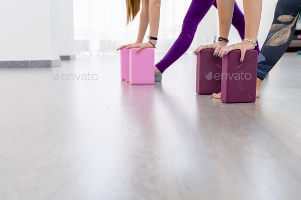 Close-up a women leans her palms on pink yoga blocks. concept yoga accessories and equipment