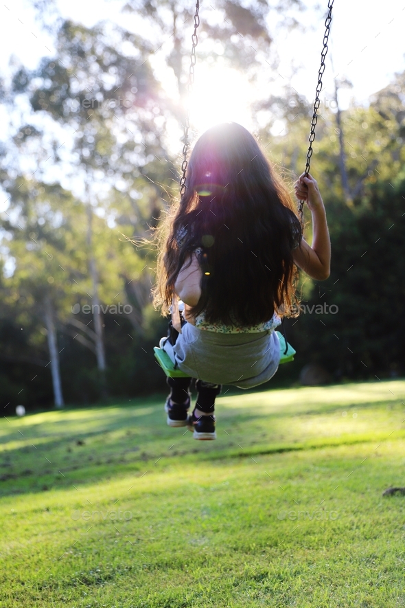 Child swinging outdoors  - Stock Photo - Images