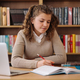 Girl studying among books using laptop - PhotoDune Item for Sale