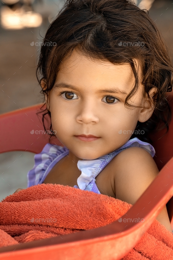 Little toddler girl sitting at beach cafe in the summer - Stock Photo - Images