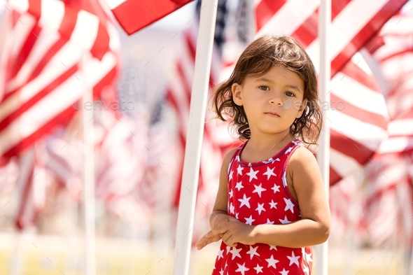 Candid portrait of toddler girl celebrating 4th of July in the park - Stock Photo - Images