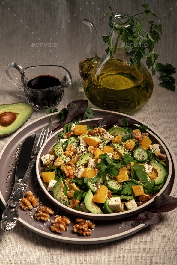Salad with arugula, avocado, orange, feta, cucumber, parsley, walnut, chia and sesame seeds.