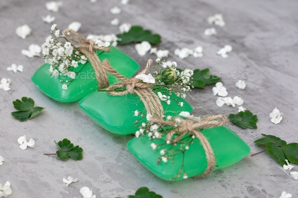 Personal hygiene. three bars of green soap are beautifully decorated with fresh flowers. Skin care.