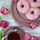 Spring layout with pink tulips, a cup of tea and pink donuts on a light background - PhotoDune Item for Sale