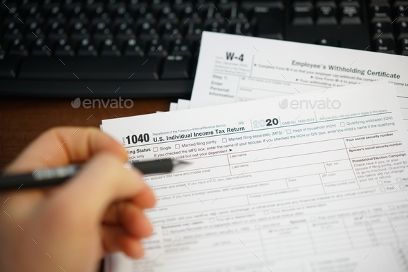Filling US tax papers  - Stock Photo - Images
