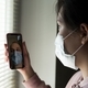 Portrait of a young girl wearing a disposable medical mask, using a  mobile phone for a video call - PhotoDune Item for Sale