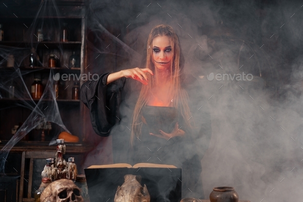 Halloween, witch use magic book and cauldron prepare poison or love ...