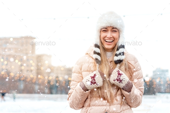 Woman in fluffy fur hat winter jacket standing outdoor in snowfall Christmas mood