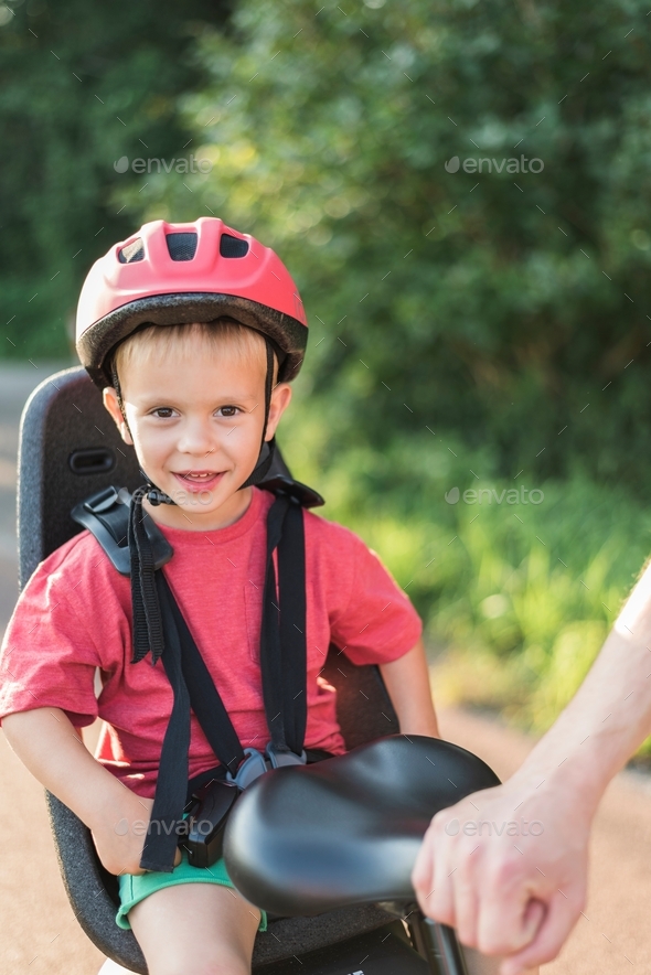 A boy seats in the bicycle seat. - Stock Photo - Images
