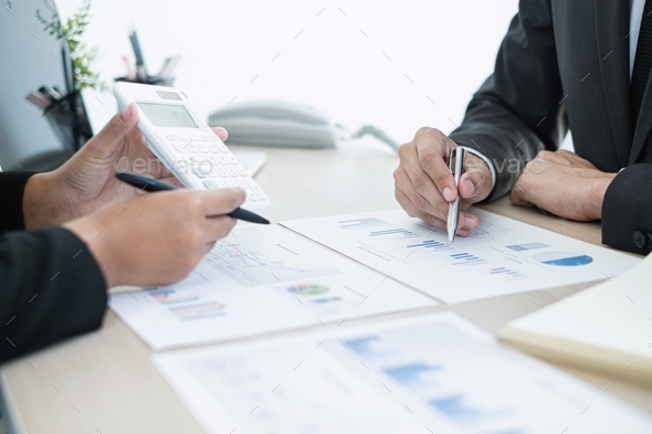 Two business leaders talk about charts, financial graphs showing results are analyzing - Stock Photo - Images