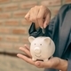 Asian businesswomen hold piggy banks and put coins in piggy banks to save money with coins to step - PhotoDune Item for Sale