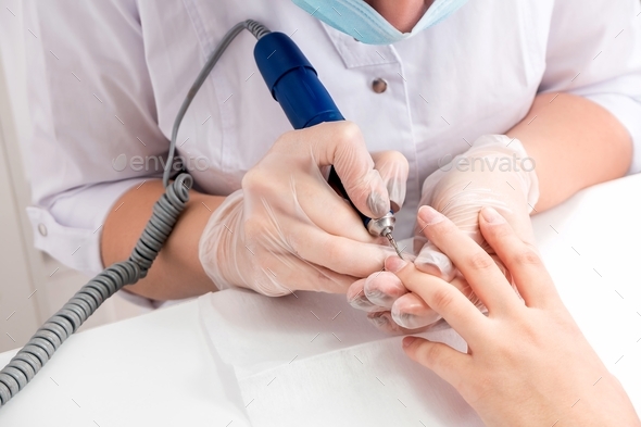 Close-up of female hands during a manicure procedure in the salon. Self-care, time for yourself.